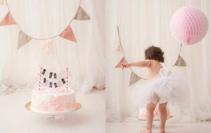 Bebé jugando con el pastel de cumpleaños en la sesión fotográfica de smash cake